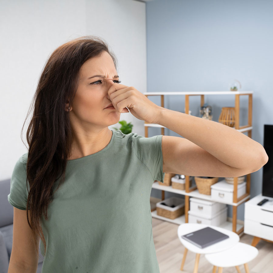 woman-holding-nose-in-smelly-room A woman holding nose in a smelly room in Pensacola, FL