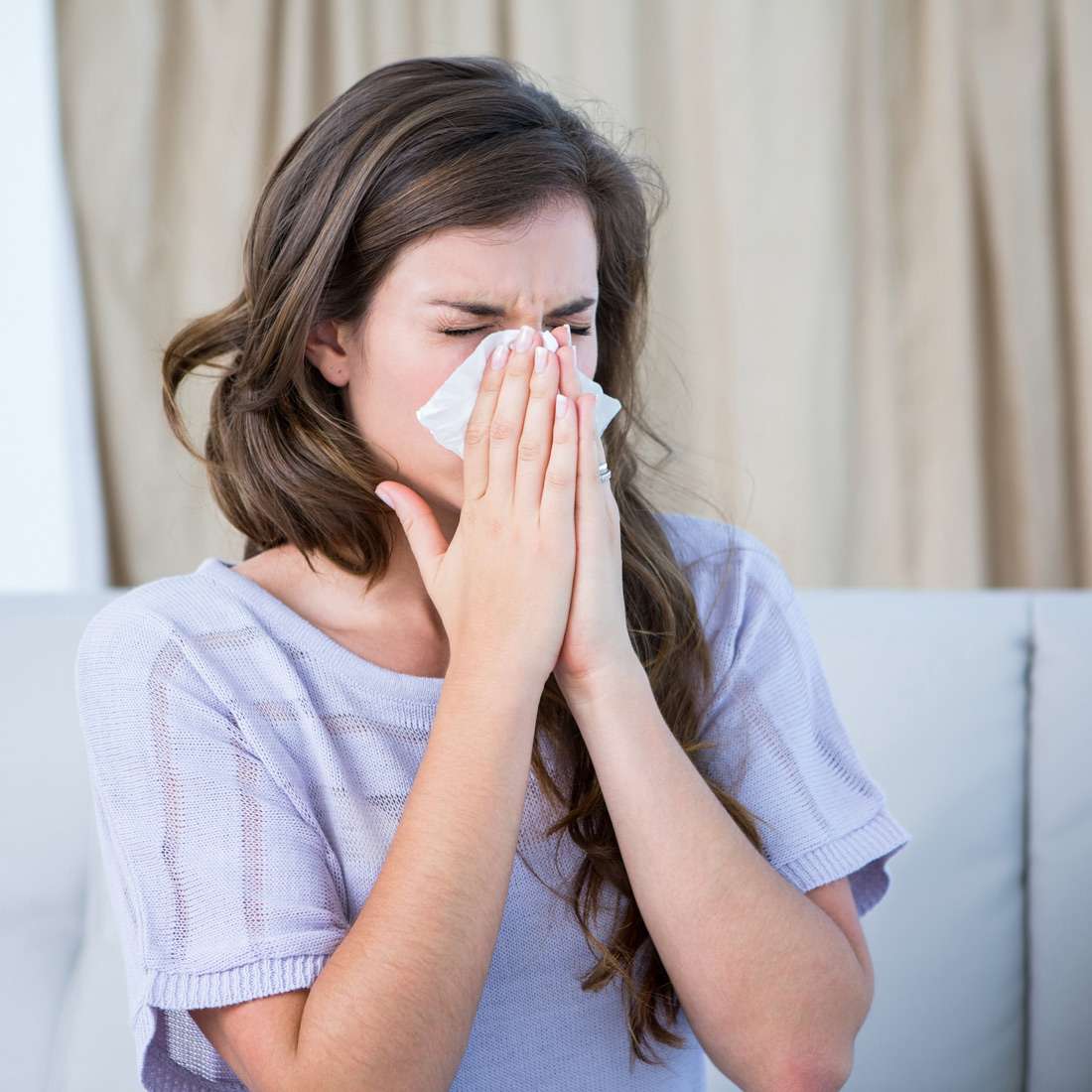 woman-blows-nose A woman blowing her nose using a tissue in Pensacola, FL
