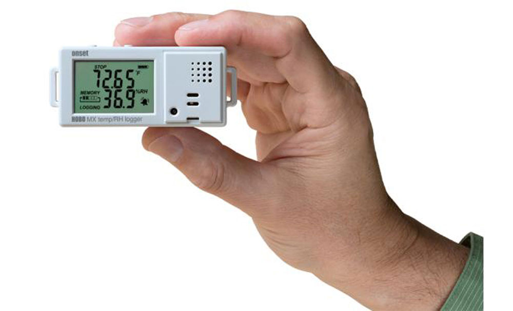 A hand holding a small digital thermometer in Pensacola, FL<br />